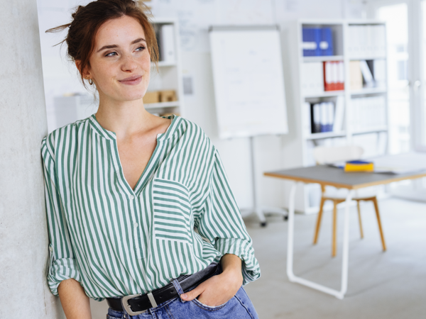 Frau in Büroumgebung freut sich über Mailing-Management